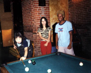 Michie from Shonen Knife hustles Mike Randle of Baby Lemonade at pool